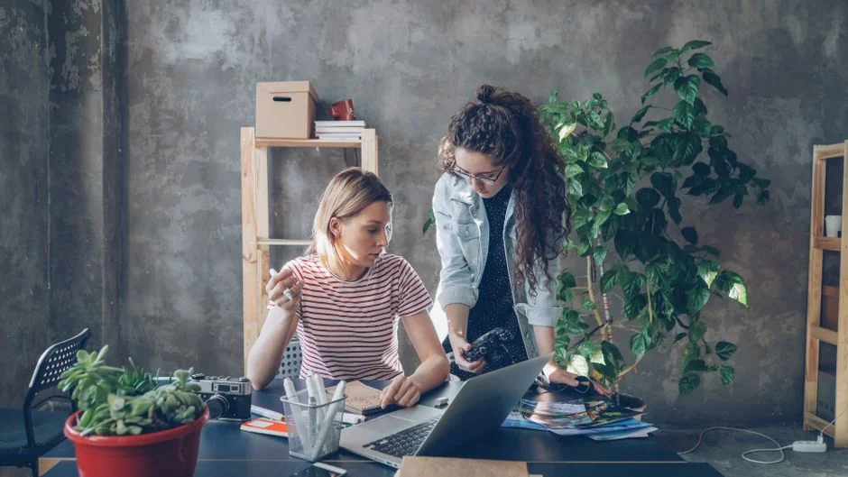 A woman wearing headphones leads an online webinar from her home office.